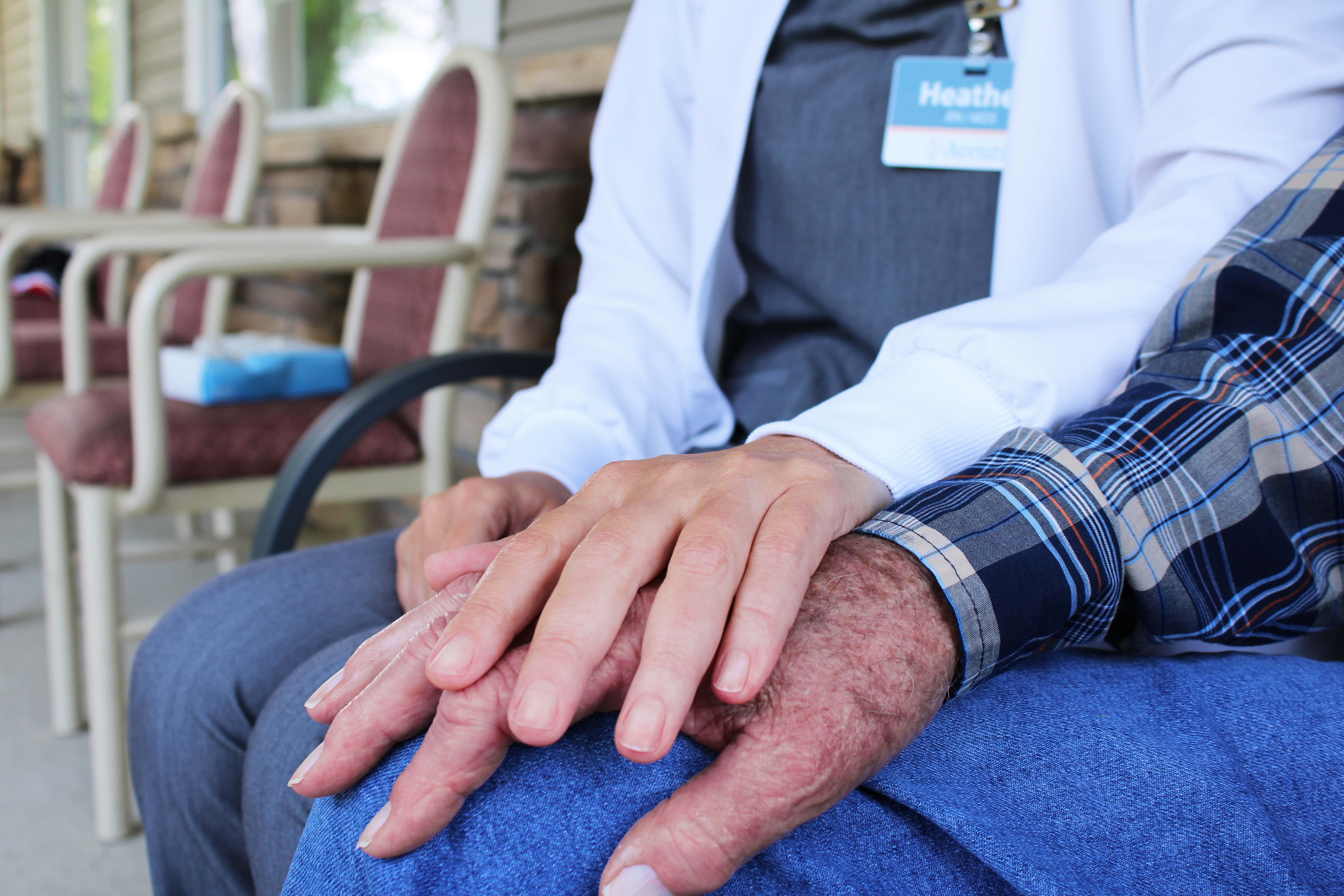 Accura HealthCare staff member holding the hands of a resident outside